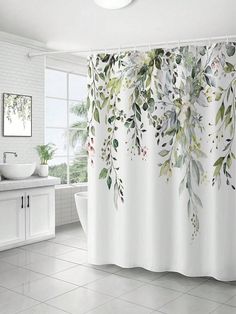 a bathroom with a shower curtain that has leaves on it