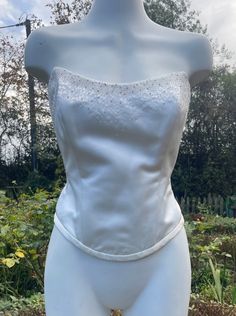 "off white satin bodice/ corset . pronuptia, vintage size 16. please see measurements. closer to a 12-14. Boned bodice with zip up back and lovely beaded top. very good clean condition. measured flat chest 18\" waist 15\" pit to hem 10\"" Wedding Corset With Lined Fitted Bodice, Sleeveless Satin Wedding Bodice, Sleeveless Satin Bodice For Wedding, Strapless Wedding Corset With Lined Bodice, Satin Wedding Corset With Boned Bodice, Fitted Lined Bodice For Wedding, Wedding Satin Corset With Boned Bodice, Strapless Satin Wedding Corset, Strapless Satin Corset For Wedding