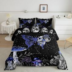 a bed covered in black and blue comforters with skulls on the covers, butterflies flying over them