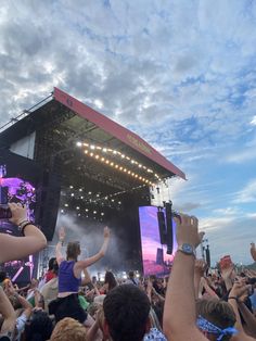 a group of people standing on top of a stage with their hands in the air