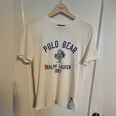 Polo Bear Graphic Tee. Super Soft Cotton, Ivory Body With “Ranch Bear” Graphic On Front, “Hand Written” Script And Embroidered Embellishments On Front And Back. Custom-Fit Medium. Nwot. Never Been Worn. Classic Embroidered Short Sleeve Top, Casual White Tops With Embroidered Logo, White Embroidered Crew Neck Shirt, White Embroidered Graphic Tee, Classic Cotton Top With Embroidered Graphics, Classic Embroidered Cotton Tops, Classic Embroidered Cream Top, Classic Cream Embroidered Top, White Crew Neck Top With Embroidered Graphics