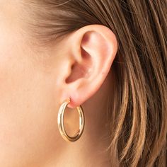 14K yellow gold 30 x 4 mm thick classic polished hoop earring set with latch back closure. Model features 30 mm. Also available in 40 mm