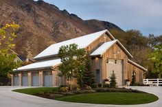 a large house with a white fence and mountains in the backgrouds behind it