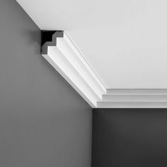 a black and white photo of a corner in a room with the ceiling painted gray