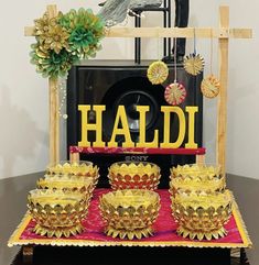 a table topped with lots of bowls and plates next to a sign that says haldi