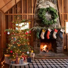 a christmas tree with stockings hanging from it's sides in front of a fireplace