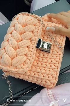 a woman's hand is holding an orange purse