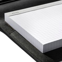 an open notebook on top of a black folder