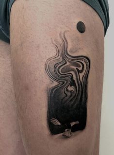 a man's thigh with a black and white tattoo on it