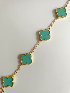 Adorn your wrist in elegance with our exquisite Clover Bracelet. Inspired by the iconic symbol of luck, this bracelet is crafted from the finest gold plating. Elevate any outfit with this sophisticated and exclusive piece, perfect for those with a taste for luxury. Luxury Turquoise Bangle Bracelets, Elegant Turquoise Adjustable Charm Bracelet, Green Luxury Jewelry With Adjustable Chain, Luxury Green Jewelry With Adjustable Chain, Elegant Blue Gold-plated Bracelets, Elegant Turquoise Bracelets With Adjustable Chain, Elegant Turquoise Bracelet With Adjustable Chain, Elegant Turquoise Jewelry, Tarnish Resistant, Elegant Blue Bangle Charm Bracelet