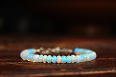 ** One of the most magical gems: Opal ** Opal is the birthstone of our October-born friends. Silver & Opals! What a de-luxe combination! This minimalist solid gemstone bracelet featuring breathtaking Ethiopian Opals, that are showing an enormous fire in all colors with a fantastic inner glow! You will love it! AAA+Grade! MATERIAL: * Natural untreated Ethiopian Opal, size: 3,5-4,5mm faceted Rondels * Strong Stainless steel Beading Wire * Sterling Silver Clasp and Components * BRACELET LENGTH Natural Opal Jewelry, Ethiopian Opal Jewelry, October Birthstone Jewelry, Healing Gemstone Bracelets, Christian Bracelets, Boho Style Earrings, Tourmaline Bracelet, Jewelry Bracelets Silver, Bracelets Diy