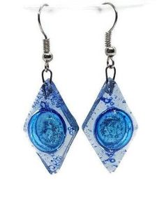 earrings with blue glass and silver wire hanging from hooks on a white background, the image is