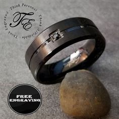 two wedding rings sitting next to each other on top of a rock with the words free engraving