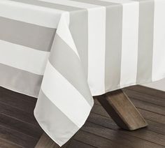 a white and grey striped tablecloth on a wooden table