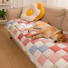 a brown dog laying on top of a couch next to a stuffed animal toy and pillow