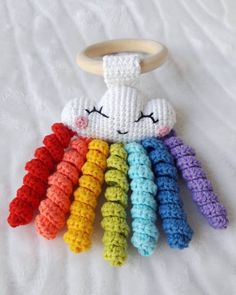 a crocheted rainbow toy with a wooden ring