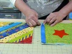 a person is cutting up some fabric on a piece of paper that has been sewn together