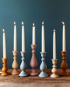 a row of candles sitting on top of a wooden table