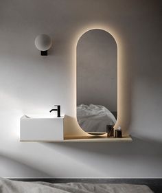 a white sink sitting under a mirror next to a wall mounted faucet in a bedroom