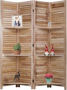 a room divider made out of wooden slats with plants and pictures on the shelves