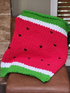 a watermelon blanket sitting on top of a brown chair