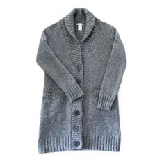 Step into the nostalgia of the 90s with this exquisitely made GAP cardigan, a blend of classic style and cozy comfort.       *   Authentic Vintage Quality: Sourced from the iconic 1990s, this GAP cardigan embodies classic comfort with timeless style.       *   Premium Material: Crafted from 100% lambswool, ensuring a soft, warm, and luxurious feel.       *   Unique Design: Features a sophisticated midi length that reaches mid-thigh, perfect for layering over your favorite outfits.       *   Deta Classic Gray Wool Cardigan, Classic Gray Cardigan For Fall, Cozy Wool Cardigan With Button Closure, Gray Wool Cardigan For Winter, Classic Soft Knit Sweater Coat For Winter, Cozy Wool Sweater With Button Closure, Cozy Wool Sweater Coat With Button Closure, Charcoal Wool Sweater For Fall, Classic Gray Knit Cardigan