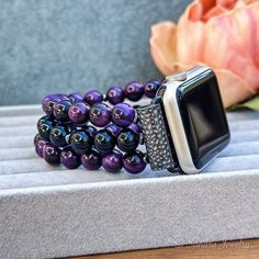 Please note that the length of the bracelet does not include the watch Introducing the IWatch Handmade Replacement Band - an exquisite fusion of craftsmanship and sophistication tailored for Apple Watches. This artisanal watch band is meticulously crafted with genuine Purple Tiger Eye stone and a striking Black Onyx middle row, creating a distinctive accessory that effortlessly combines style and functionality. Choose from a spectrum of connector colors - black, silver, and rose gold - to seamle Elegant Adjustable Apple Watch Band With Round Beads, Elegant Adjustable Beaded Watch Bands, Elegant Beaded Apple Watch Band As Gift, Elegant Adjustable Apple Watch Band As Gift, Elegant Adjustable Apple Watch Band For Gift, Elegant Adjustable Apple Watch Band Gift, Purple Tiger, Apple Watch Bracelet, Apple Watch Bracelets