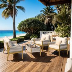 a wooden deck with chairs and tables on it next to the ocean in front of palm trees