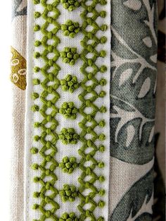 some green beads are on the side of a piece of fabric that has been stitched together