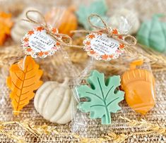 some cookies are sitting on a table with fall decorations in the background and tags attached to them