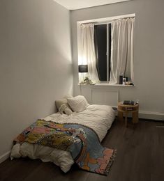 a bedroom with white walls and wooden floors