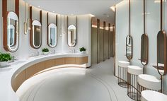 a large bathroom with round mirrors and sinks