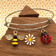 Bee Bracelet, Ladybug Bracelet, Flower Bracelet, Garden Bracelet, Spring Bracelet, Gift for Gardener, Bee Bangle Bracelet, Bee Charm  ️ Keep spring in your heart...and on your wrist...all year long! - charms are  comprised of skin safe enamel - come gift ready  in a cute organza bag  - bracelets are  hypoallergenic stainless steel, in a gold or plain silver       finish - bracelets are adjustable Please choose either a gold or silver bracelet.  All charms are gold and jump rings will match the b Adjustable Flower Charms Bracelets, Adjustable Flower-shaped Bracelets With Charms, Adjustable Flower-shaped Charm Bracelets, Adjustable Bangle Charm Bracelet With Extender, Flower-shaped Bracelets With Charms For Gift, Adjustable Charms Bangle, Adjustable Charm Bangle With Lobster Clasp, Adjustable Metal Bracelet With Flower Charm, Adjustable Flower Bracelets With Lobster Clasp