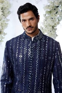 Midnight sherwani features all-over mirror work on a raw silk base. Paired with an off-white cotton kurta and a afghani cotton silk salwar.
Components:3
Pattern:Embroidered
Type of Work:Mirror Work
Neckline:Mandarin
Sleeve Length:Full Sleeves
Fabric:Raw Silk
Color:Blue
Other Details:
Mirror work
Note: Pocket square worn by the model is not for sale
Occasion:Sangeet - Aza Fashions Designer Nehru Jacket With Mirror Work For Festive Season, Designer Nehru Jacket With Mirror Work For Eid, Designer Nehru Jacket With Mirror Work For Diwali, Designer Nehru Jacket With Mirror Work For Festivals, Designer Ceremonial Kurta With Mirror Work, Designer Kurta With Mirror Work For Festive Occasions, Designer Festive Kurta With Mirror Work, Designer Festive Kurta With Gota Work, Designer Gota Work Kurta For Diwali