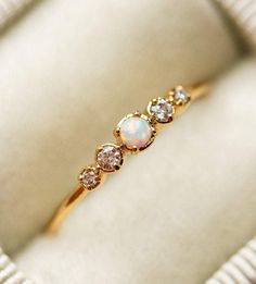 an opal and diamond ring in a box