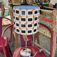 a lamp sitting on top of a red chair next to a table with chairs around it