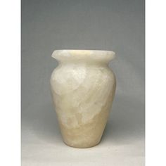 a white vase sitting on top of a table