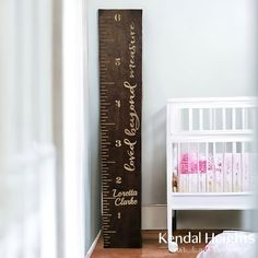 a tall wooden ruler next to a white crib in a baby's room