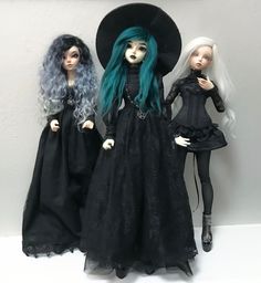 two dolls dressed in black and white are standing next to each other