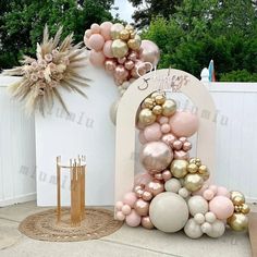 a large balloon arch with pink, gold and white balloons