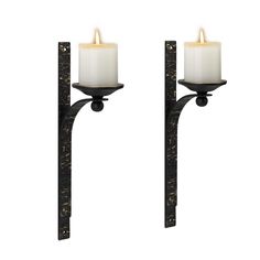 two candle holders with candles on them against a white background, one is black and the other is gold