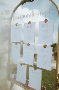 a wooden easel with seating cards attached to it