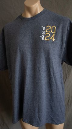 Celebrate your graduation year with our Class of 2024 T-shirt. Made with high-quality fabric and gold embroidery, this shirt is perfect for showing off your school pride.  5.5-ounce, 50 cotton/50 polyester material DryBlend moisture-wicking properties Classic fit, seamless body Shipping is extra and mailed out on Fridays. UPS is our preferred shipping method, with USPS being an alternative. We also offer FREE local delivery and pick-up. Use code LOCAL to cover shipping and someone will reach out Gold Cotton Crew Neck Shirt, Cotton Crew Neck T-shirt For Graduation, Crew Neck T-shirt For College Graduation Events, School Spirit Cotton T-shirt For Graduation, Graduation Party Shirts, Senior Shirts, Graduation Year, School Pride, Gold Embroidery