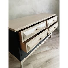 a white and black dresser sitting on top of a hard wood floor