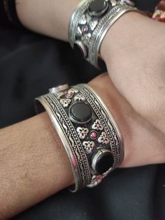 * This traditional craft is embellished with black stones and intricate carved designs, inspired by the true Afghani ornaments. The light in weight, yet exclusive bracelet would add an ethnic touch to your attire. The pick tiny stones are complimenting the tribal style of the hand accessory. You can pair this elegant ornament with any traditional or trendy attire, as per your liking. Note: The product is handmade, so slight change might occur in the actual product. Heavy Metal Bracelet For Festival, Heavy Metal Bracelets For Festival, Heavy Adjustable Metal Bracelet, Bohemian Oxidized Bangle For Festivals, Adjustable Traditional Bracelets For Rituals, Metal Bracelets For Rituals, Bohemian Oxidized Bangle Bracelets, Oxidized Bangle Bracelets For Festival, Traditional Metal Bracelets For Festivals