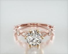 a rose gold engagement ring with an oval cut diamond in the center and side stones