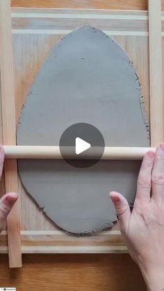 two hands are working on a piece of wood with a large circle in the middle