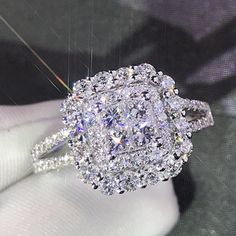 a close up of a diamond ring on a person's finger