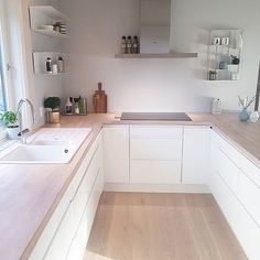 a kitchen with white cabinets and wooden floors is shown on the instagramr page