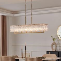 a chandelier hanging over a dining room table with chairs and a mirror on the wall